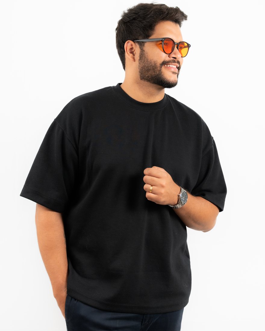 Retrato de estúdio de um homem de camiseta preta com a mão no peito